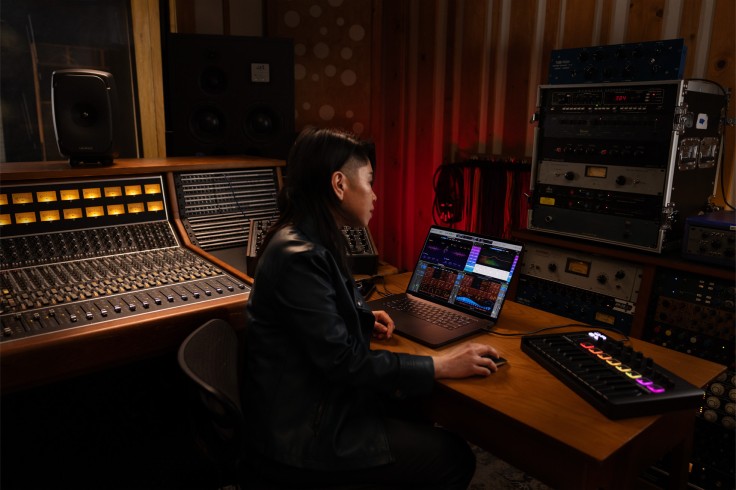 Productor trabajando en el estudio de Apple Music con una computadora portátil y mezclando