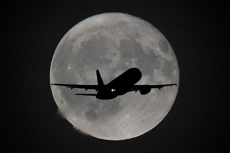 Se ve un avión de pasajeros con la luna detrás mientras comienza su aproximación de aterrizaje final en el aeropuerto de Heathrow en Londres.